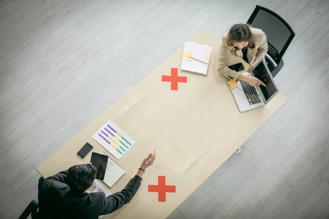 birdseye-view-of-man-and-woman-having-a-socially-distanced-business-meeting-at-a-table