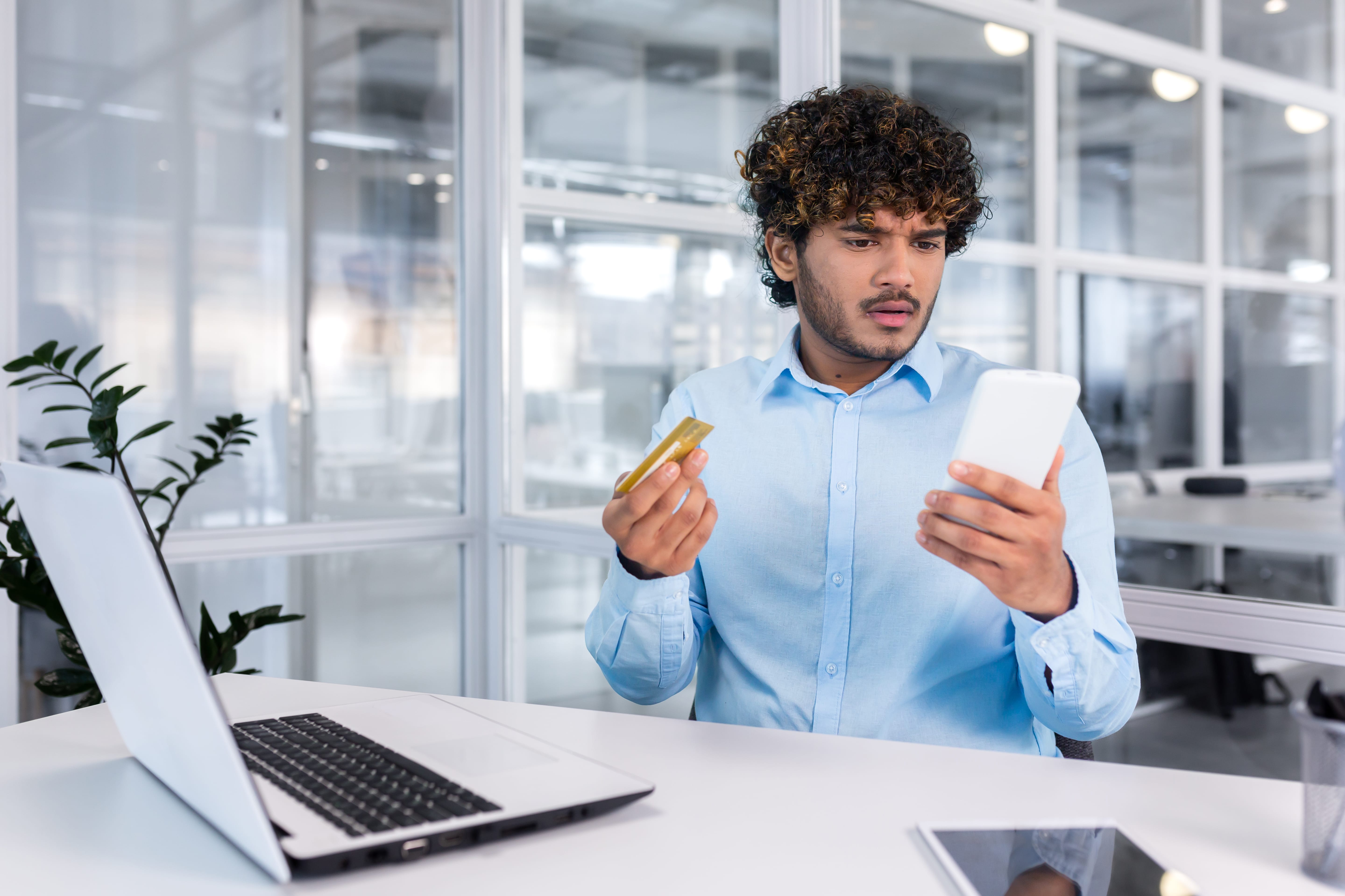 Confused business owner looking at a credit card